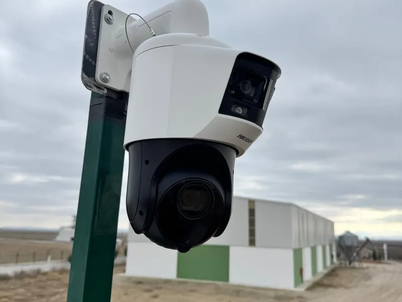Tesis girişinde direğe monte edilmiş çift lensli Hikvision PTZ kamera.